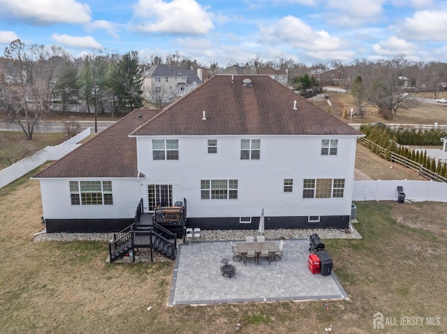 rear view of house featuring a patio area, a wooden deck, and a yard