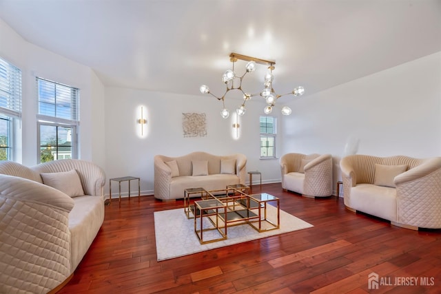 living room featuring dark wood-type flooring, plenty of natural light, and a chandelier