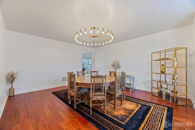 dining space with wood-type flooring and an inviting chandelier