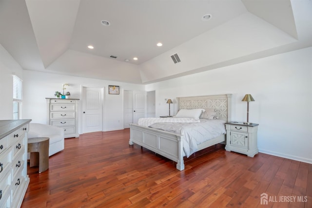 bedroom featuring dark hardwood / wood-style flooring and a raised ceiling