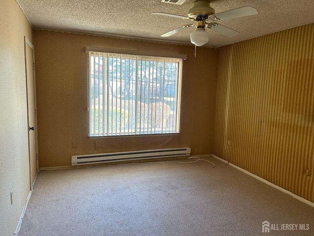 spare room featuring visible vents, a ceiling fan, a textured ceiling, carpet flooring, and a baseboard radiator