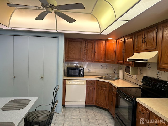 kitchen featuring sink, decorative backsplash, light tile patterned floors, ceiling fan, and black appliances