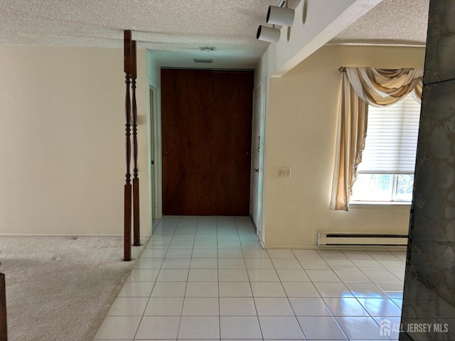 hall featuring a baseboard heating unit, light tile patterned floors, light colored carpet, and a textured ceiling