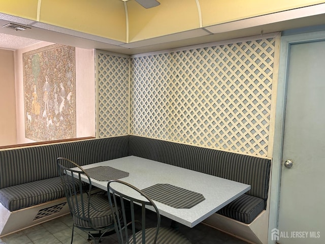 tiled dining area featuring breakfast area, visible vents, and ceiling fan