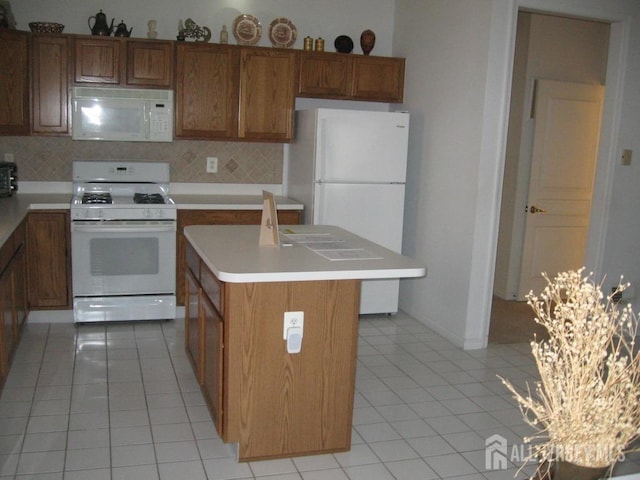 kitchen featuring white appliances, tasteful backsplash, and brown cabinetry