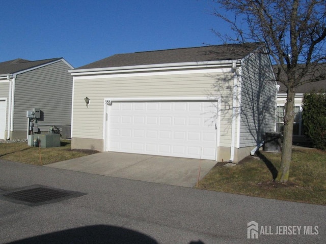 view of side of property with a garage, driveway, and cooling unit