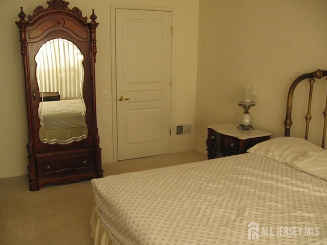 bedroom featuring visible vents and light colored carpet