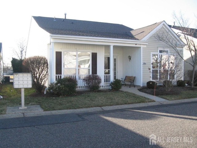 view of front facade featuring covered porch and a shingled roof