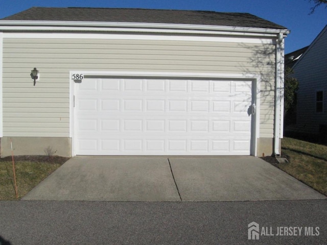 garage featuring concrete driveway