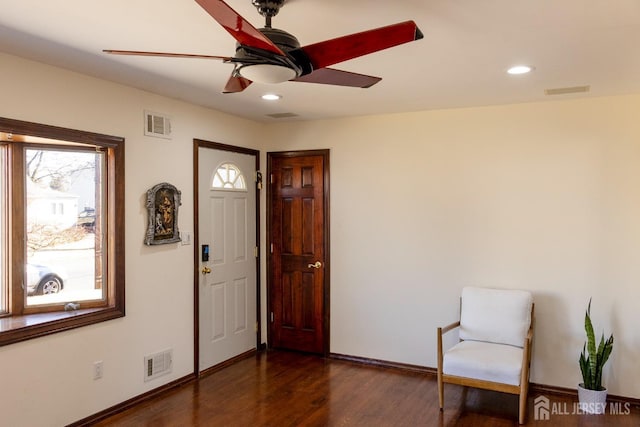 sitting room with visible vents, ceiling fan, baseboards, and wood finished floors