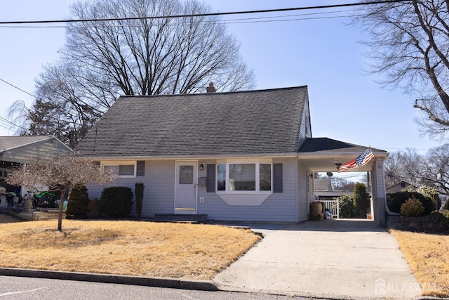 view of front of house featuring a chimney, a shingled roof, entry steps, a carport, and driveway