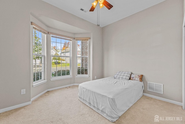 carpeted bedroom featuring multiple windows, visible vents, and baseboards