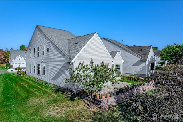 view of property exterior with a yard and a shingled roof