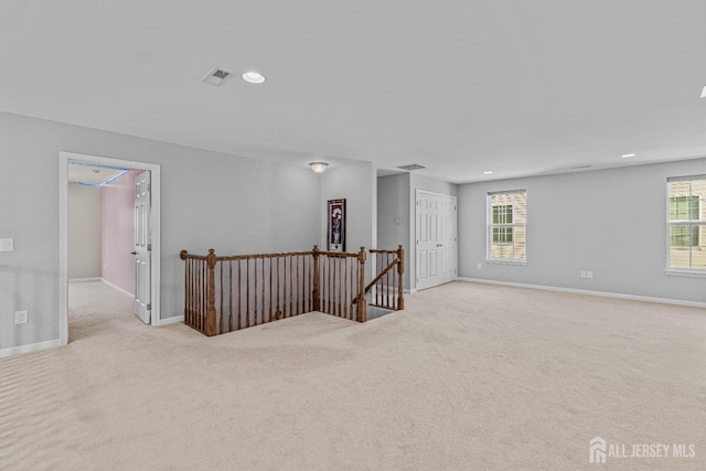 spare room featuring recessed lighting, carpet flooring, visible vents, and baseboards