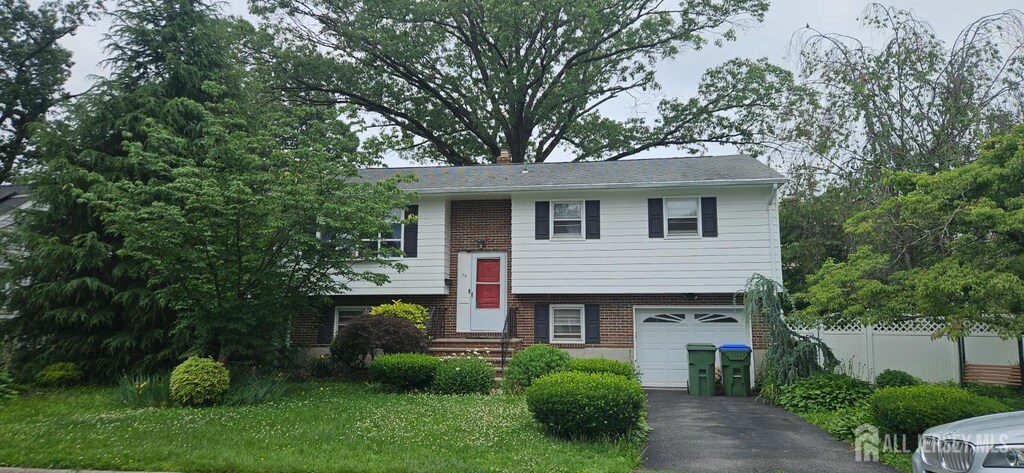 56 Orange St, Edison, NJ 08817 - split foyer home with an attached garage, driveway, and brick siding