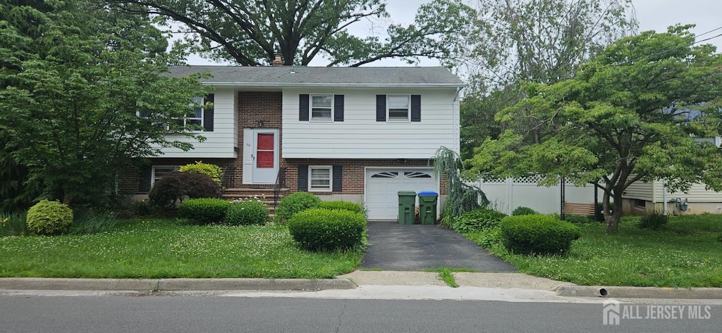 56 Orange St, Edison, NJ 08817 - raised ranch featuring brick siding, a garage, and driveway
