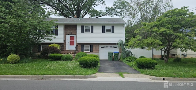 56 Orange St, Edison, NJ 08817 - raised ranch featuring brick siding, a garage, and driveway