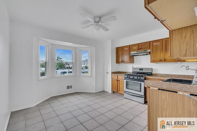 17 Begonia Ct, Sayreville, NJ 08872 - kitchen with stainless steel range with gas stovetop, under cabinet range hood, light countertops, ceiling fan, and light tile patterned floors