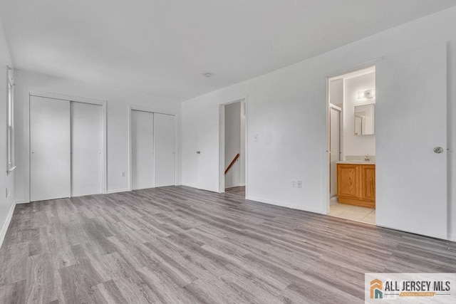 17 Begonia Ct, Sayreville, NJ 08872 - unfurnished bedroom featuring multiple closets, light wood-type flooring, and ensuite bathroom