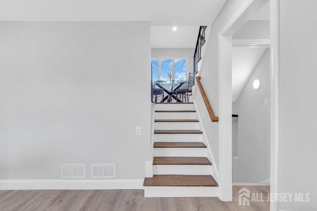 staircase with wood-type flooring