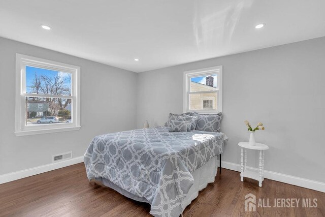 bedroom featuring dark wood-type flooring and multiple windows