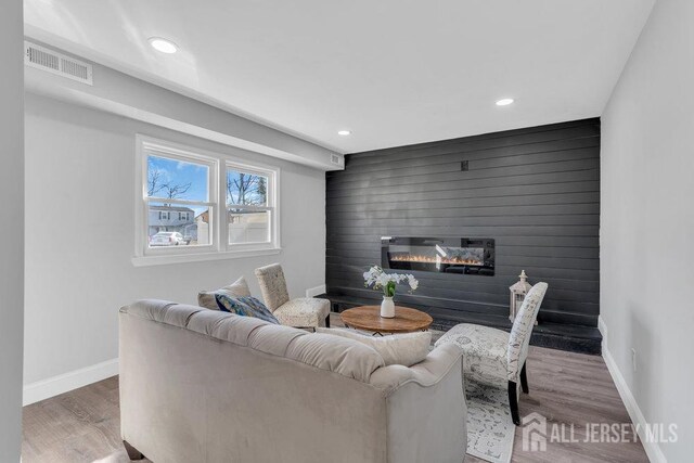 living room with a fireplace and wood-type flooring