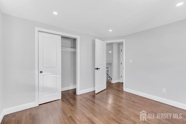 unfurnished bedroom featuring hardwood / wood-style floors and a closet