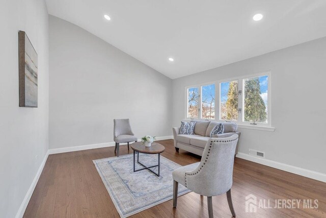 living room featuring hardwood / wood-style flooring and vaulted ceiling