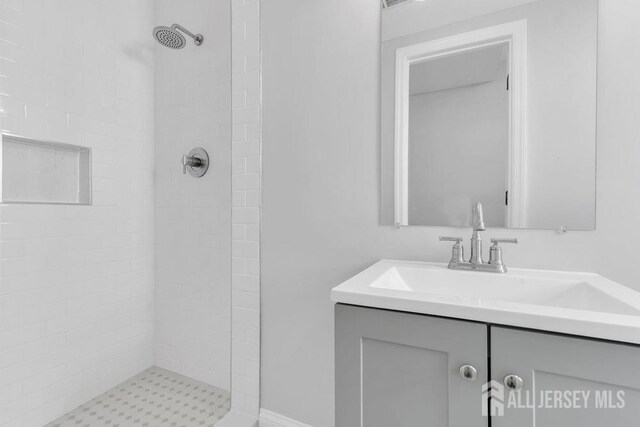 bathroom featuring vanity and tiled shower