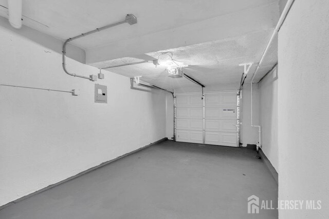 garage with a garage door opener and electric panel