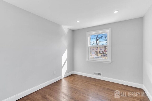 unfurnished room with hardwood / wood-style floors