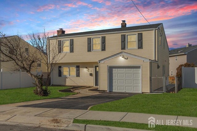 view of front of property featuring a garage and a yard