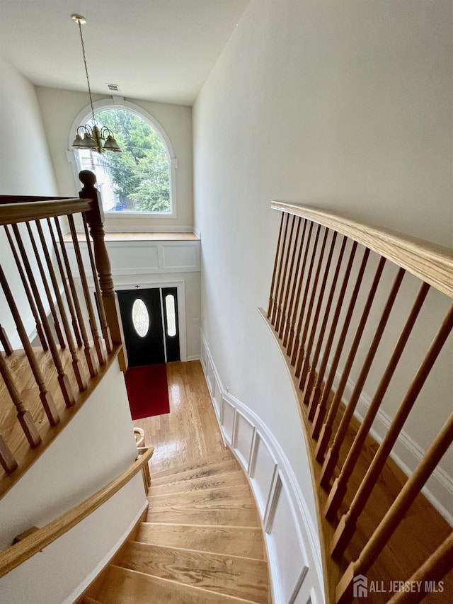 89 Sharot St, Carteret, NJ 07008 - stairway with wood finished floors and a chandelier