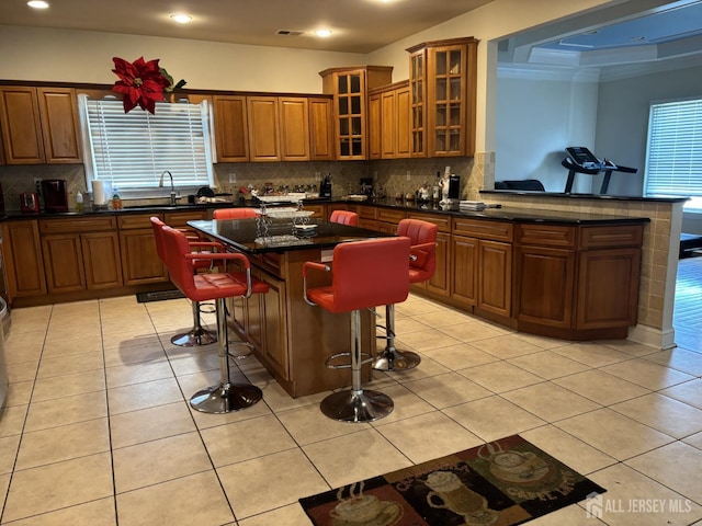 89 Sharot St, Carteret, NJ 07008 - kitchen featuring a kitchen bar, tasteful backsplash, brown cabinetry, a center island, and recessed lighting