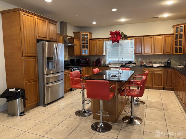 89 Sharot St, Carteret, NJ 07008 - kitchen with stainless steel fridge with ice dispenser, brown cabinetry, a breakfast bar area, decorative backsplash, and recessed lighting