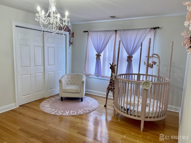 89 Sharot St, Carteret, NJ 07008 - bedroom featuring wood finished floors, a chandelier, a nursery area, and a closet