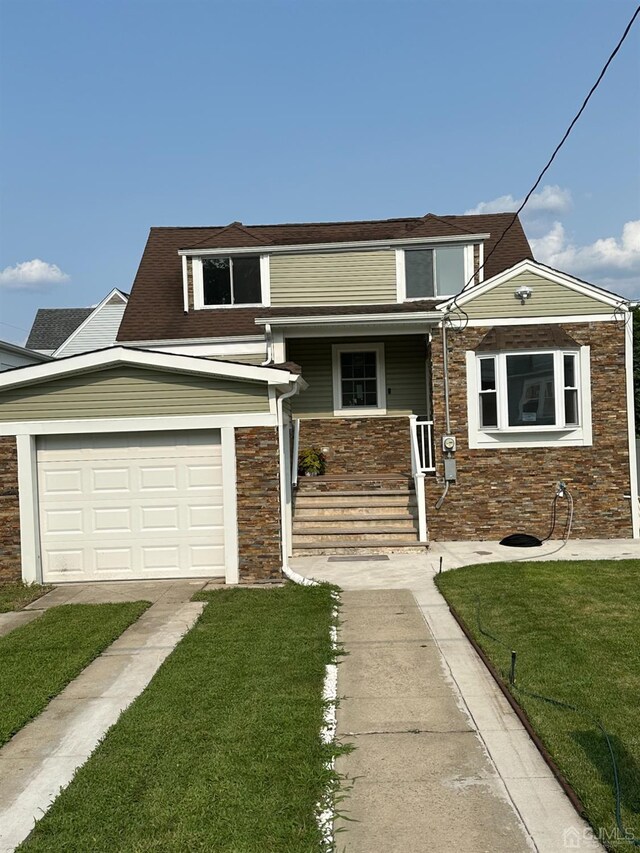 view of front of property featuring a porch, a front lawn, and a garage