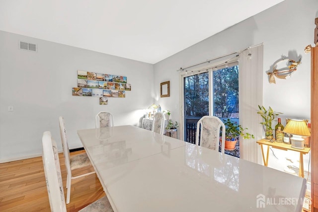 dining area with visible vents and wood finished floors