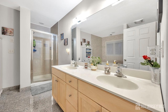 bathroom with double vanity, a stall shower, visible vents, and a sink