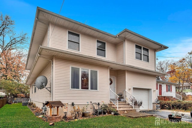 view of front of home featuring central AC unit, driveway, a front lawn, and an attached garage