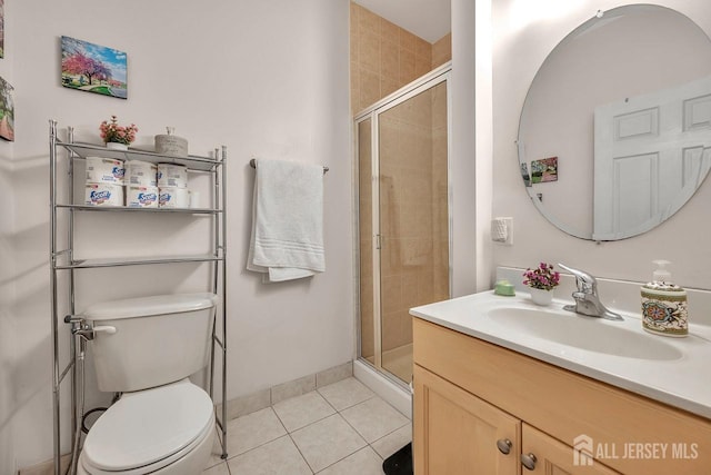 bathroom with toilet, a shower stall, vanity, and tile patterned floors