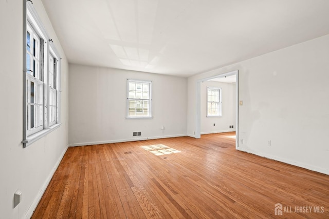 unfurnished room with visible vents, baseboards, and light wood finished floors