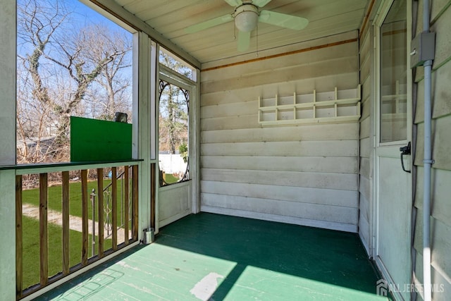 unfurnished sunroom featuring ceiling fan