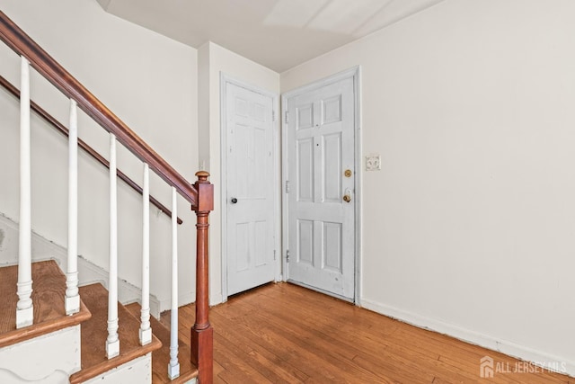 foyer featuring stairway, baseboards, and light wood-style floors