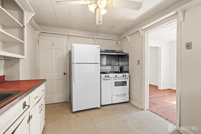 kitchen featuring dark countertops, ceiling fan, under cabinet range hood, white cabinets, and white appliances