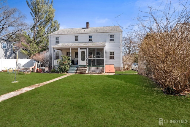 back of property featuring a lawn, fence, a sunroom, and a chimney