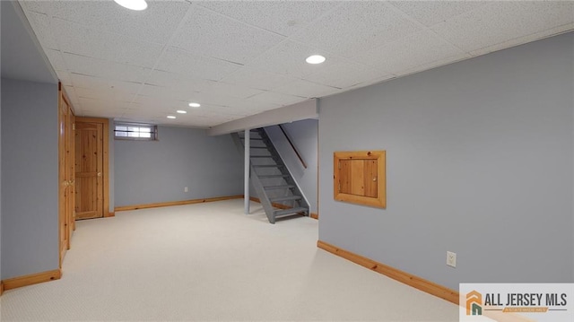 below grade area featuring recessed lighting, baseboards, carpet, and stairs