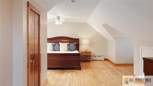 bedroom with a ceiling fan, vaulted ceiling, baseboard heating, wood-type flooring, and baseboards