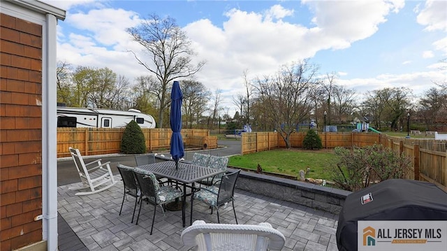 view of patio featuring outdoor dining area, a fenced backyard, and a grill