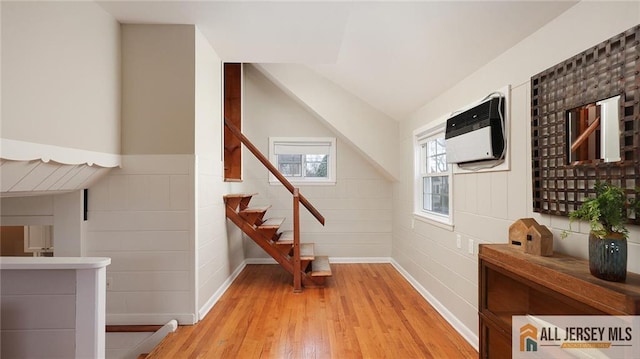 interior space with wood finished floors, baseboards, and lofted ceiling